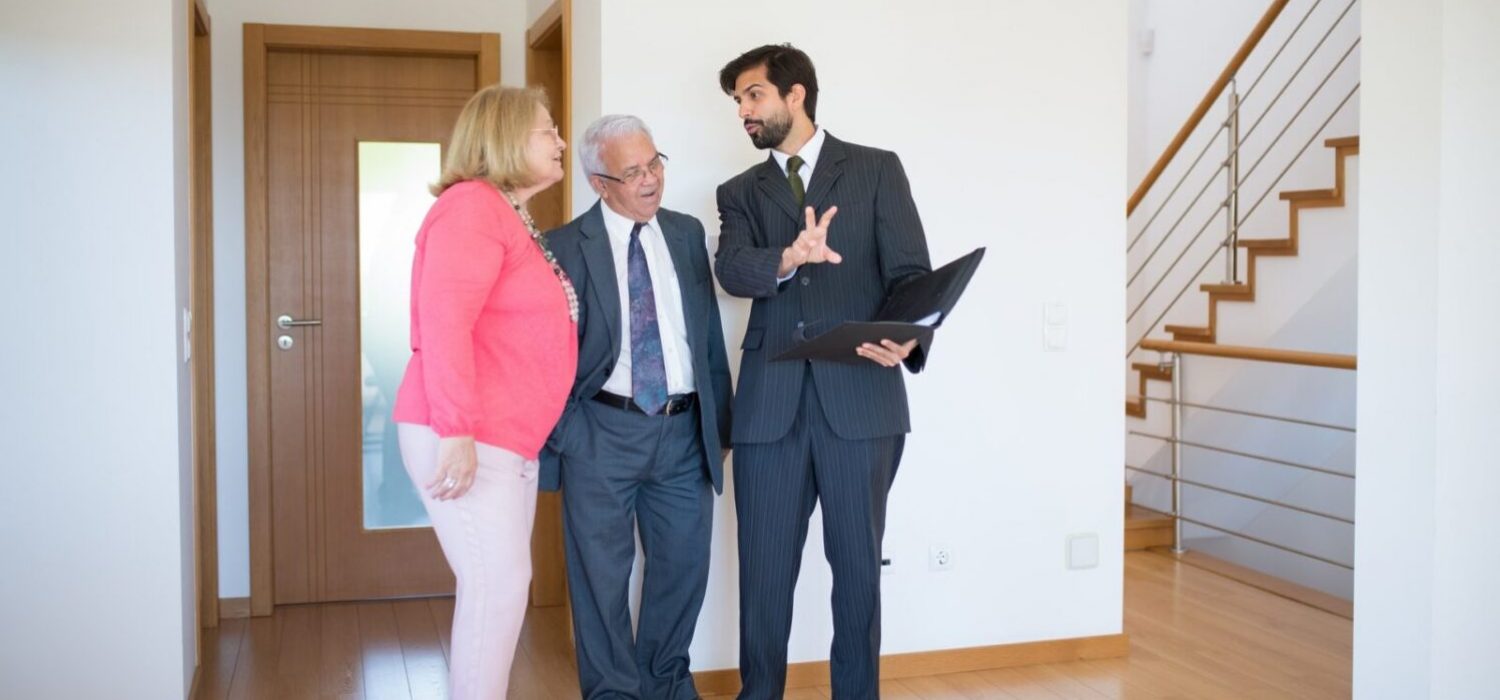 real estate agent assisting a couple by showing them a property